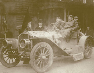 Colonel Sam Bailey. Note the Pullman headlight flags and the promotional banner draped over the hood.